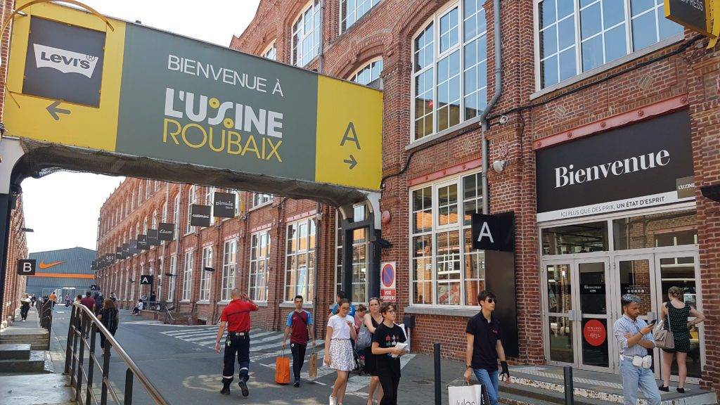Village de Noël du centre commercial Usine Roubaix avec ses chalets illuminés, décorations féeriques, animations pour enfants et ambiance festive dans un cadre industriel réenchanté